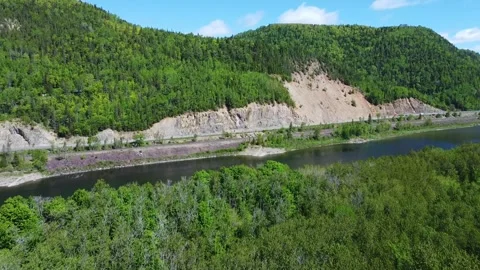 Rocky cape at mountain bordered by a road parallel to the Ristigouche River. Stock Footage 304300371