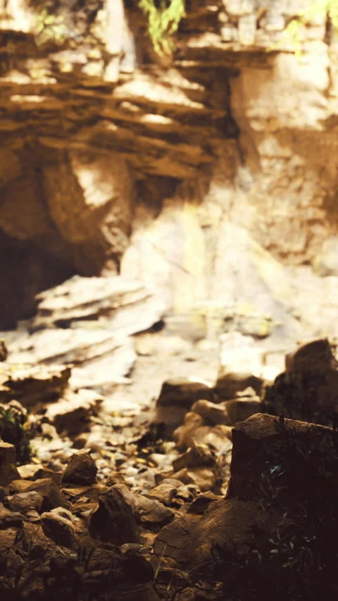 Rocky cave with sunlight filtering through and scattered stones Stock Footage 334260083