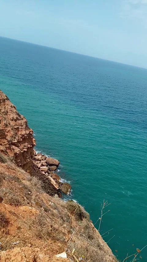 Rocky Cliff Overlooking Turquoise Ocean Coastline Stock Footage 335480256