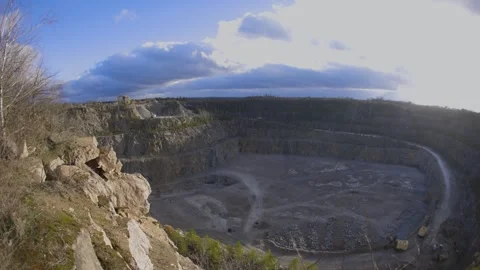 A rocky cliff with sparse trees and dry bushes under warm sunlight. Video stock 304003784