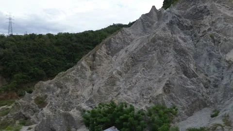 Rocky cliff with trees on a cloudy day Stock Footage 265570421