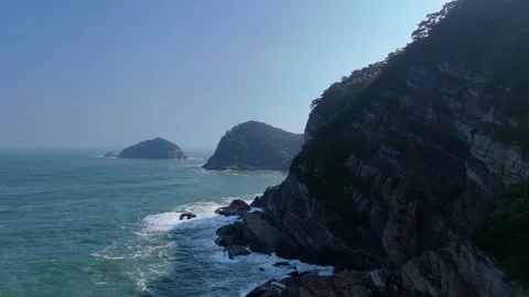 Rocky cliffs and crashing waves at amnam park in busan Stock Footage 341908766