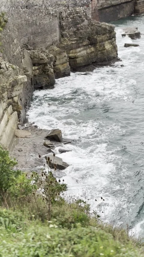 Rocky cliffs and powerful waves. Vertical video. Stock Footage 299103117