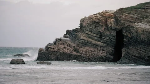 Rocky cliffs on the beach being hit by high tide. 스톡 동영상 169748688