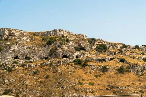 Rocky cliffs with prehistoric cave openings on the Murgia plateau across the Stock Photos