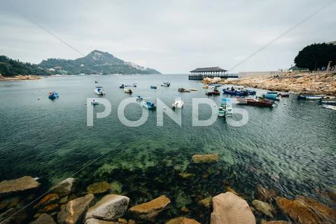 Rocky coast and boats at Stanley, on Hong Kong Island, Hong Kong. Stock Photos