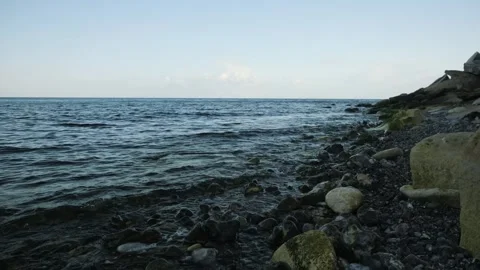 Rocky Coast Featuring Calm Flowing Waters. Distant Horizon Over Peaceful Pebble Stock Footage 345500123