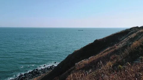 Rocky coast of the ocean overlooking the ship  Stock Footage 84005612
