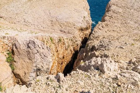Rocky coastal canyon with ocean view on a sunny day Stock Photos
