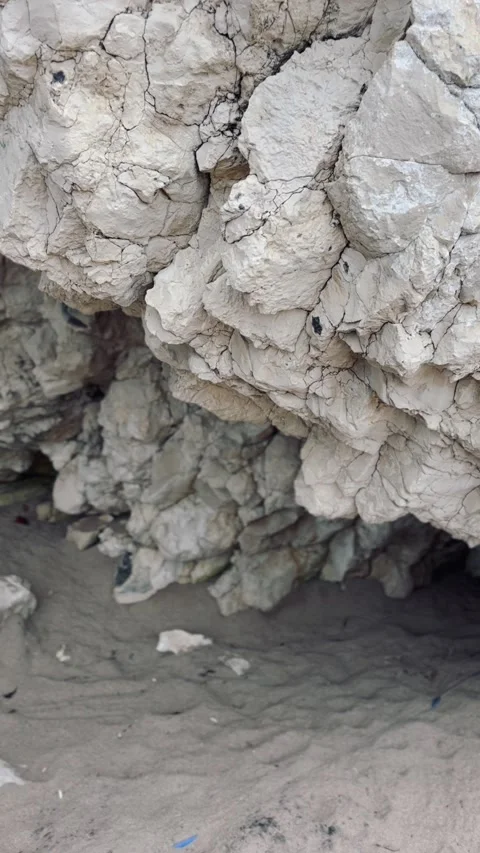Rocky Coastal Cave Opening onto a Sandy Beach Stock Footage 314194155