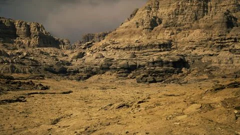 Rocky desert landscape with rugged formations and dry terrain under cloudy sk Stock Illustration