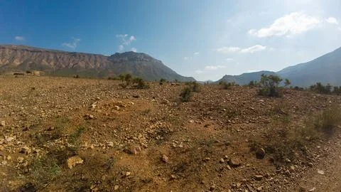 Rocky desert plain with distant mountains under blue sky Stock-Fotos