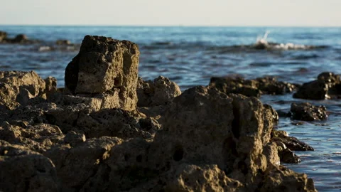 Rocky Foreground With Gentle Sunset Waves in the Background Stock Footage 341658642