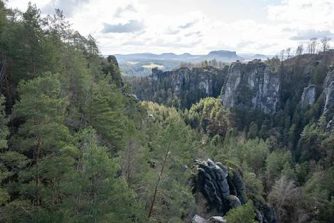 Rocky formation mountains with sharp edges in the green forest cloudy Stock Photos
