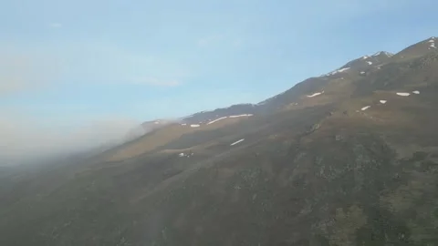Rocky gray mountains without vegetation in haze with blue sky. Drone video. Video stock 253768966
