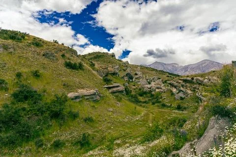 Rocky Green Hillside Under Dramatic Cloudy Sky Stock Photos