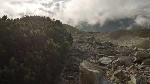 Rocky high top of the mountain with fast moving clouds. sunset after the rain Vidéo 77546446
