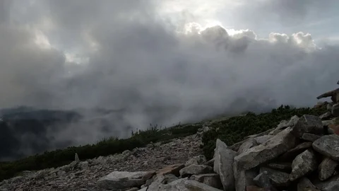 Rocky high top of the mountain with fast moving clouds. sunset after the rain Stock Footage 77555951