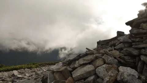 Rocky high top of the mountain with fast moving clouds. sunset after the rain Stock Footage 77571590