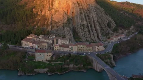 Rocky hill glows in evening light above old town in southern France Stock Footage 307312685