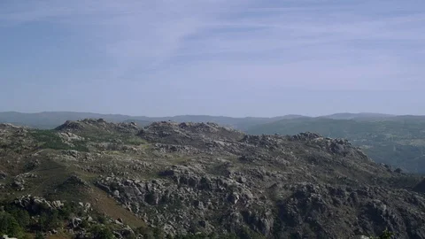Rocky hill landscape with cloudy blue sky in background, Portugal Stock Footage 129067501