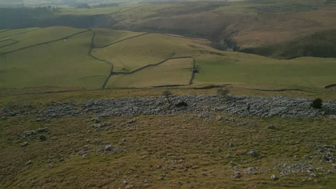 Rocky hillside pull away revealing green patchwork fields in English Stock-Footage 233569845