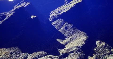 Rocky landscape with deep shadows captured in natural light at midday Stock Illustration