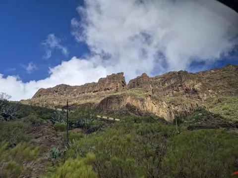 Rocky mountain cliff under dramatic cloudy sky Stock Photos
