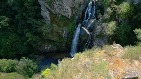 Rocky Mountain Cliffs With Pristine Waterfall On A Sunny Summer Day 動画素材 250525581