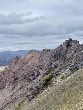 Rocky mountain ridge with dramatic peaks and layered geological formations under Stock Photos
