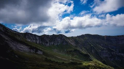 Rocky mountain ridge under dramatic blue sky with clouds Stock Photos