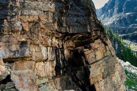 A rocky mountain side displaying layers of sedimentary rock formations. Stock Photos