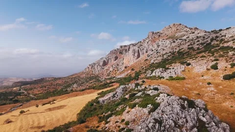 Rocky mountain slope with grasslands and clouds Видео 331226053