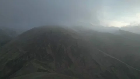 Rocky mountains without vegetation covered with clouds at dawn. Drone video. Video stock 253764919