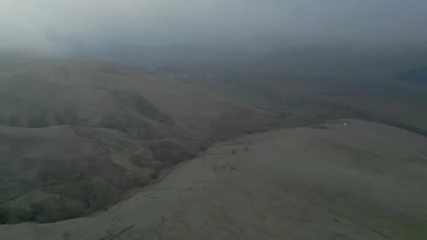 Rocky mountains without vegetation covered with clouds at dawn. Drone video. Video stock 253766172