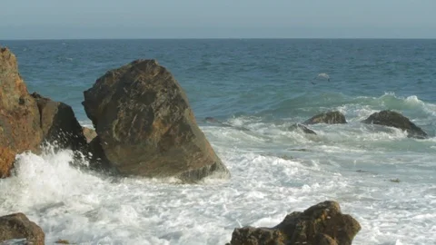 Rocky ocean front. Waves crashing into rocks on beach D Stock Footage 102402230