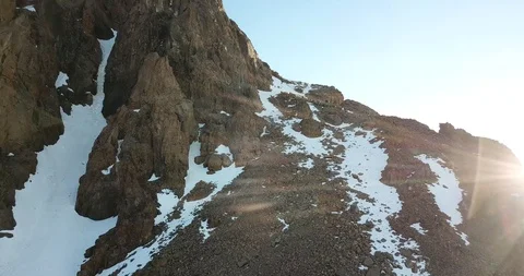 The rocky peak is covered with snow. The queue of people on the rise. Video stock 112713277