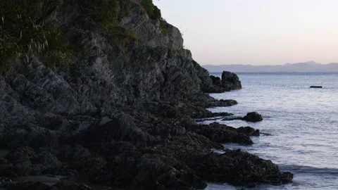 Rocky point with sun setting over mountains in distance Stock Footage 260369591