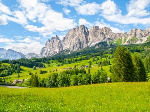Rocky ridge of Pomagagnon Mountain above Cortina d'Ampezzo with green meadows Stock Photos