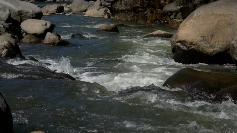 A rocky river flow that still looks natural in the countryside Video stock 287994397