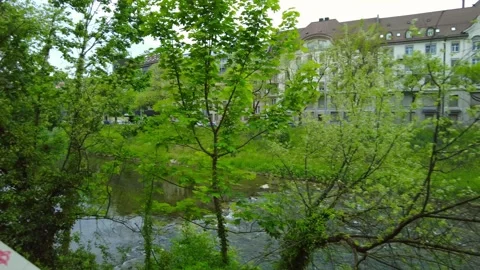 A rocky river flows through Zurich. Green Alley Stock Footage 334629612