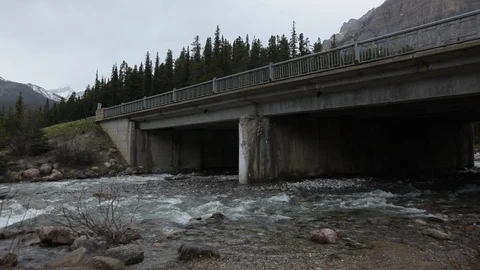 Rocky river flows under a bridge in Alberta naturescape Stock Footage 90837169