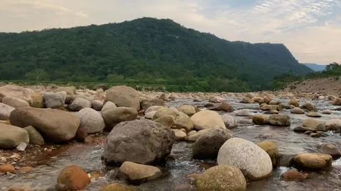 Rocky riverbed flows through natural landscape in Sylhet, Bangladesh Stockbeeldmateriaal 331784577