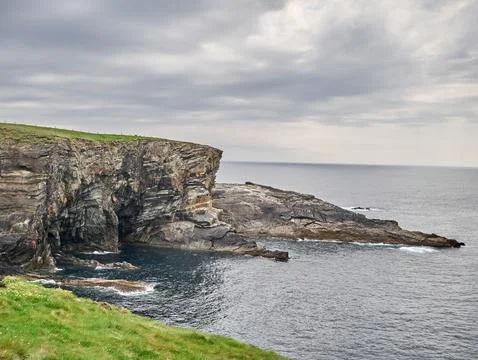 Rocky sea cliffs under a cloudy sky Stockfoto's