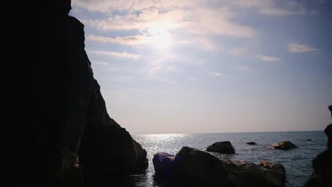 Rocky sea coast with dark cliffs and sparkling ocean water at sunset Stock-Footage 331194877
