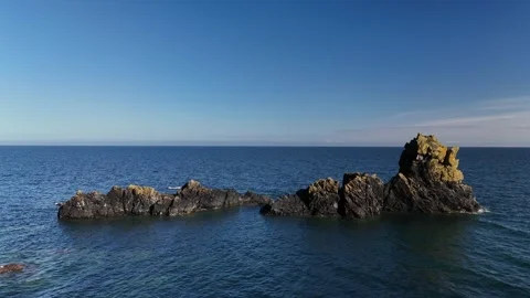 Rocky Sea Stacks and Cliffs Above Calm Ocean Water Stock-Footage 333414545