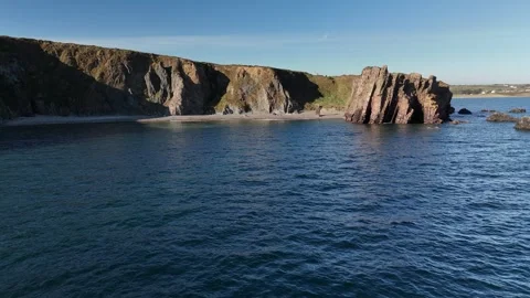 Rocky Sea Stacks and Cliffs Above Calm Ocean Water Vidéo 333414610