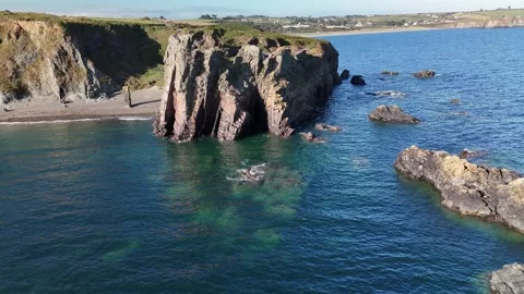 Rocky Sea Stacks and Cliffs Above Calm Ocean Water 库存影片 333414648