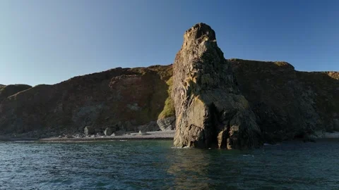 Rocky Sea Stacks and Cliffs Above Calm Ocean Water Vidéo 333414672