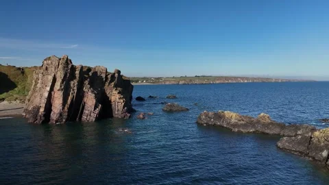 Rocky Sea Stacks and Cliffs Above Calm Ocean Water 库存影片 333414673